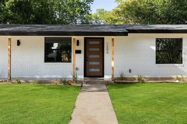 1206 Cloverleaf Dr, Austin, TX 78723 - doorway to property with brick siding, a lawn, and roof with shingles