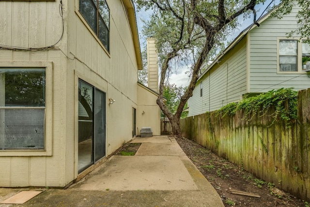 13102 Amarillo Ave, Austin, TX 78729 - view of home's exterior featuring a fenced backyard, a patio, and a chimney