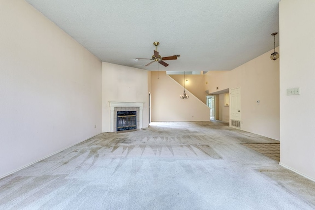 13102 Amarillo Ave, Austin, TX 78729 - unfurnished living room featuring ceiling fan, carpet flooring, a tiled fireplace, vaulted ceiling, and a textured ceiling