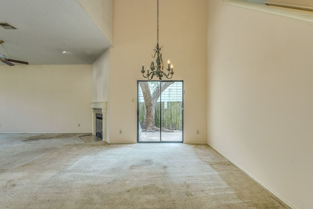 13102 Amarillo Ave, Austin, TX 78729 - spare room with carpet, a high ceiling, a chandelier, a fireplace, and ceiling fan