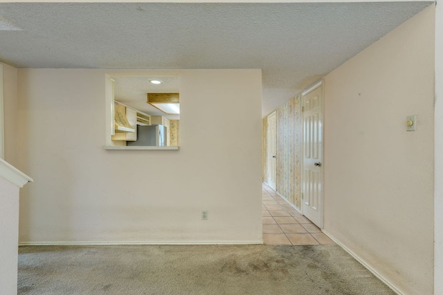 13102 Amarillo Ave, Austin, TX 78729 - spare room featuring light colored carpet, light tile patterned floors, and a textured ceiling
