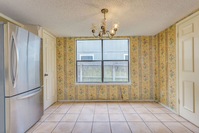 13102 Amarillo Ave, Austin, TX 78729 - unfurnished dining area with a chandelier, wallpapered walls, a textured ceiling, and light tile patterned floors