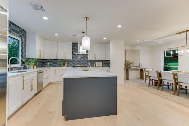 3104 Mistyglen Cir, Austin, TX 78746 - kitchen with stainless steel dishwasher, a kitchen island, wall chimney range hood, tasteful backsplash, and recessed lighting