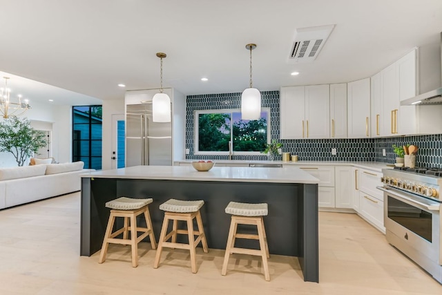 3104 Mistyglen Cir, Austin, TX 78746 - kitchen featuring high end appliances, decorative backsplash, a kitchen island, white cabinetry, and light countertops