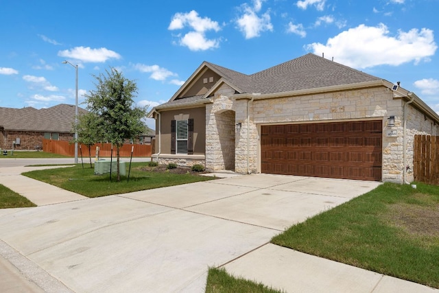 4669 Padula Dr, Round Rock, TX 78665 - view of front of house featuring stone siding, a garage, concrete driveway, and a shingled roof