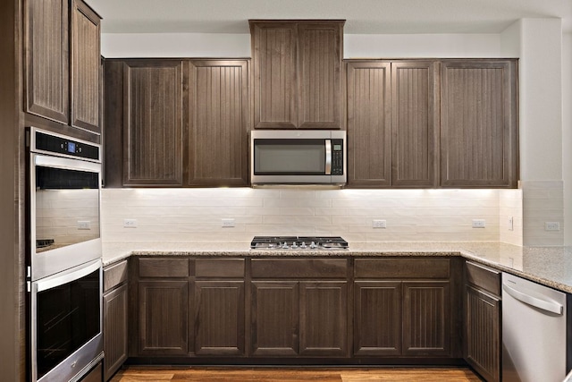 4669 Padula Dr, Round Rock, TX 78665 - kitchen featuring stainless steel appliances, tasteful backsplash, and dark brown cabinetry