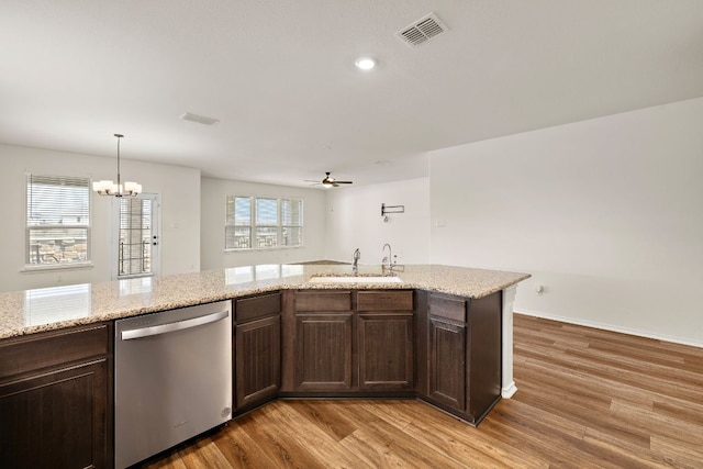 4669 Padula Dr, Round Rock, TX 78665 - kitchen with dishwasher, light wood finished floors, a chandelier, dark brown cabinets, and recessed lighting