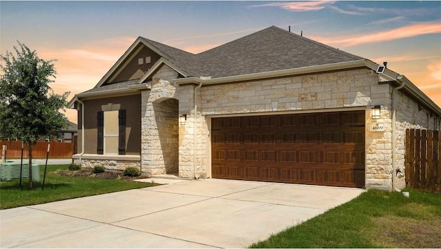 4669 Padula Dr, Round Rock, TX 78665 - view of front of house featuring stone siding, roof with shingles, a garage, and driveway