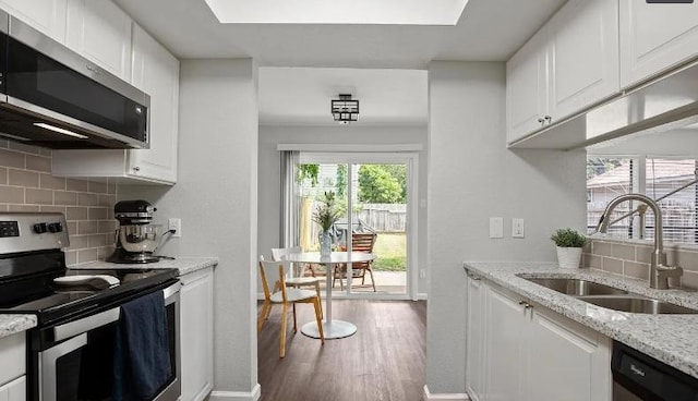 2604 Alcott Ln Unit A & B, Austin, TX 78748 - kitchen featuring appliances with stainless steel finishes, backsplash, white cabinetry, and wood finished floors