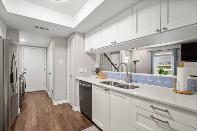 2604 Alcott Ln Unit A & B, Austin, TX 78748 - kitchen with appliances with stainless steel finishes, separate washer and dryer, light countertops, white cabinetry, and dark wood-type flooring