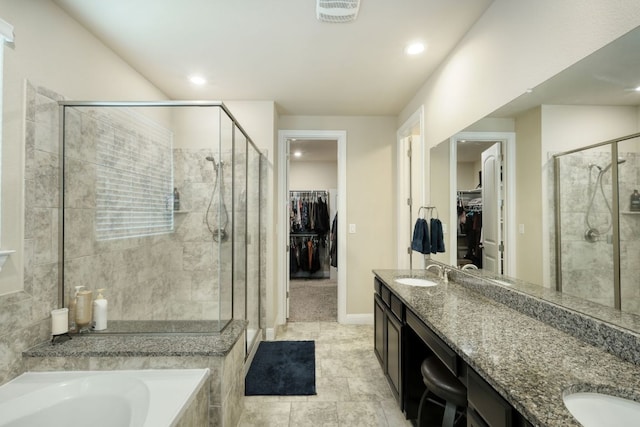 2336 Centennial Loop, Round Rock, TX 78665 - full bathroom with double vanity, a shower stall, a spacious closet, a bath, and tile patterned floors