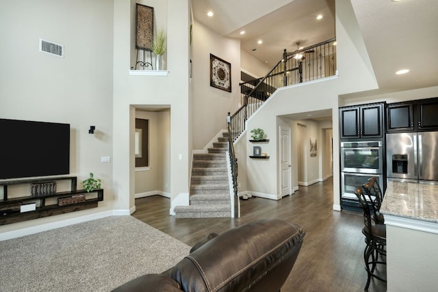 2336 Centennial Loop, Round Rock, TX 78665 - living room with a towering ceiling, stairs, recessed lighting, and dark wood-style flooring
