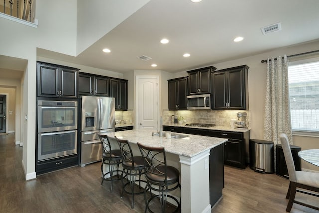2336 Centennial Loop, Round Rock, TX 78665 - kitchen with appliances with stainless steel finishes, dark wood-style flooring, backsplash, light stone countertops, and recessed lighting