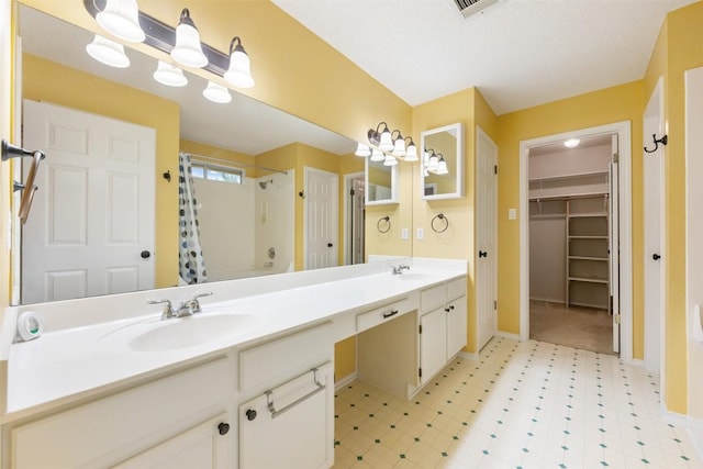 16504 Jadestone Dr, Leander, TX 78641 - full bathroom featuring curtained shower, double vanity, a walk in closet, and tile patterned floors