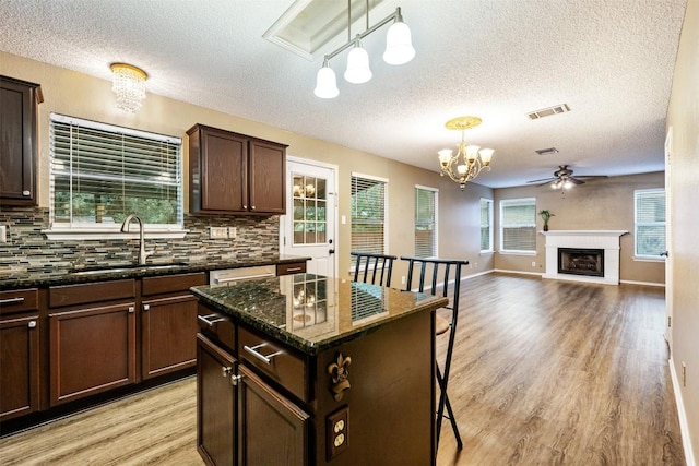16504 Jadestone Dr, Leander, TX 78641 - kitchen with a textured ceiling, light wood-style floors, a chandelier, backsplash, and ceiling fan