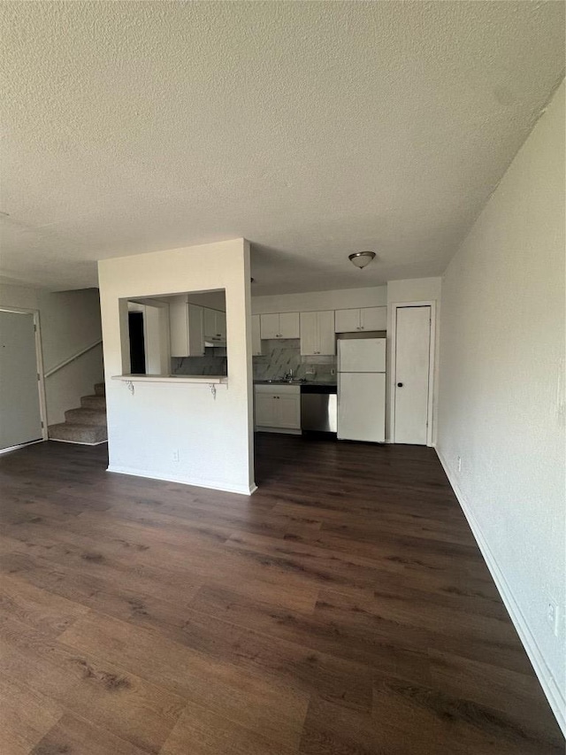 4908 W Gate Blvd, Austin, TX 78745 - unfurnished living room with a textured ceiling, dark wood-type flooring, and stairway