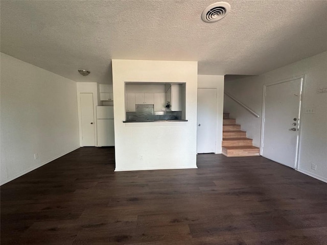 4908 W Gate Blvd, Austin, TX 78745 - unfurnished living room featuring stairs, dark wood-type flooring, and a textured ceiling