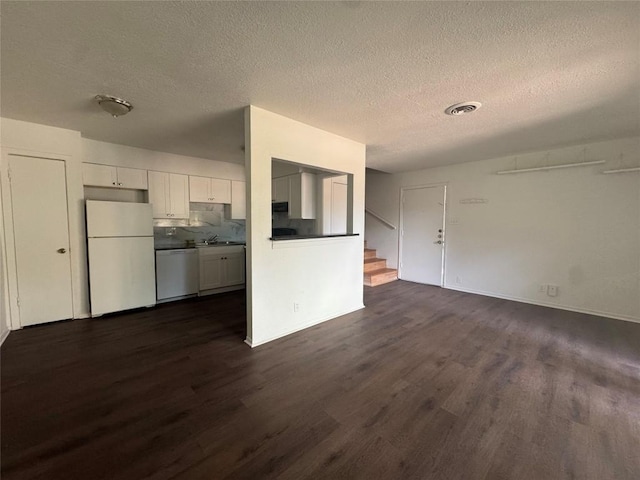4908 W Gate Blvd, Austin, TX 78745 - unfurnished living room with dark wood finished floors, a textured ceiling, and stairs