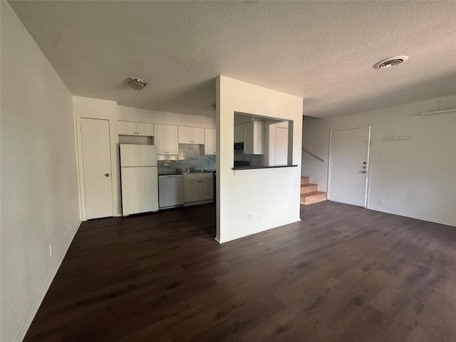 4908 W Gate Blvd, Austin, TX 78745 - unfurnished living room featuring dark wood-style floors, a textured ceiling, and stairway