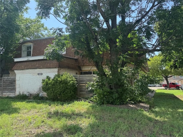 4908 W Gate Blvd, Austin, TX 78745 - view of home's exterior with brick siding, a yard, and a shingled roof