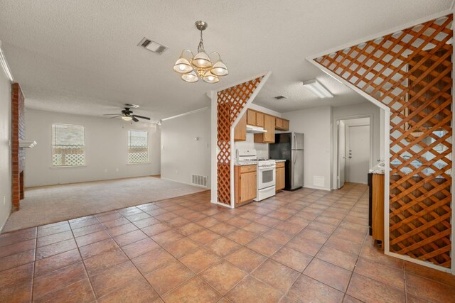 1625 Sylvia Ct, Round Rock, TX 78681 - kitchen with white range with gas stovetop, freestanding refrigerator, light carpet, ceiling fan, and a chandelier
