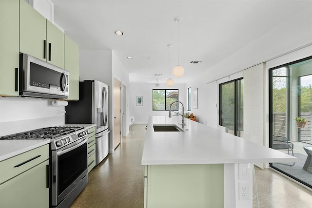 5725 Toscana Ave, Austin, TX 78724 - kitchen with stainless steel appliances, green cabinets, light countertops, a center island with sink, and recessed lighting