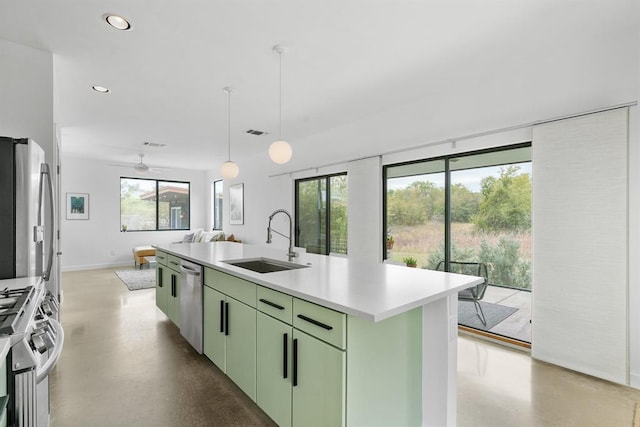 5725 Toscana Ave, Austin, TX 78724 - kitchen with appliances with stainless steel finishes, green cabinets, an island with sink, light countertops, and recessed lighting