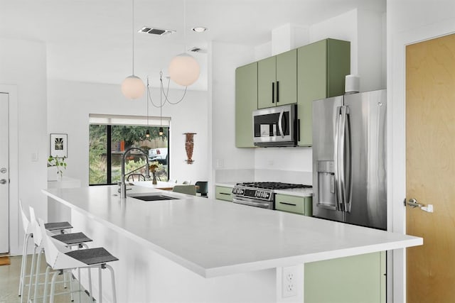 5725 Toscana Ave, Austin, TX 78724 - kitchen featuring stainless steel appliances, green cabinetry, a breakfast bar, and light countertops