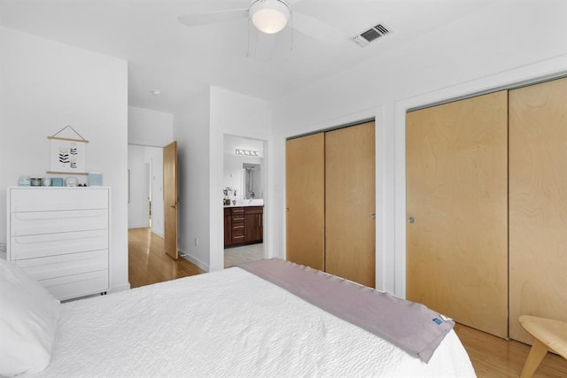 5725 Toscana Ave, Austin, TX 78724 - bedroom with wood finished floors, two closets, ensuite bath, and a ceiling fan