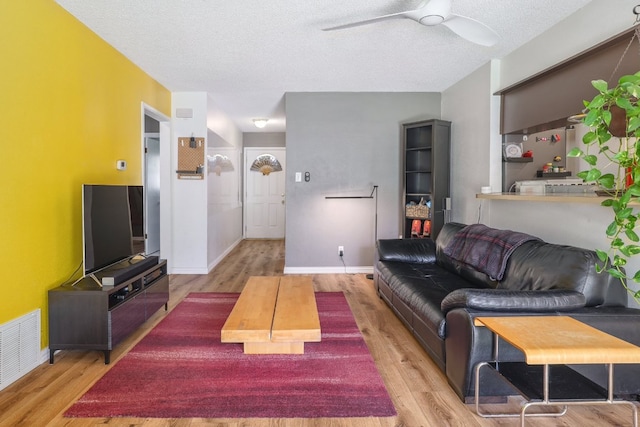 8101 Parkdale Dr, Austin, TX 78757 - living area featuring light wood-style floors, ceiling fan, and a textured ceiling