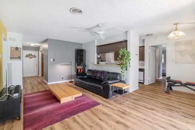 8101 Parkdale Dr, Austin, TX 78757 - living room featuring light wood-type flooring, a textured ceiling, and a ceiling fan