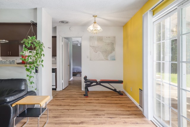 8101 Parkdale Dr, Austin, TX 78757 - exercise area featuring healthy amount of natural light, light wood-style flooring, and a chandelier