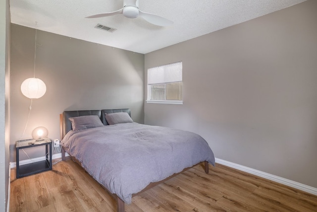 8101 Parkdale Dr, Austin, TX 78757 - bedroom with wood finished floors, a textured ceiling, and ceiling fan