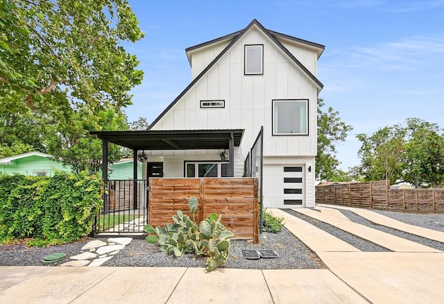 504 Normandy St Unit A, Austin, TX 78745 - view of front facade featuring board and batten siding, driveway, an attached garage, a fenced front yard, and a gate
