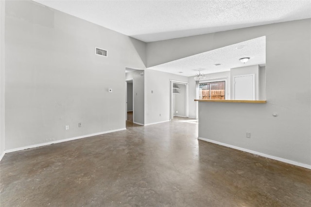 6201 Berkett Cv, Austin, TX 78745 - unfurnished living room featuring concrete floors, a textured ceiling, and a chandelier