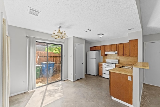6201 Berkett Cv, Austin, TX 78745 - kitchen with white appliances, under cabinet range hood, brown cabinets, a chandelier, and finished concrete flooring