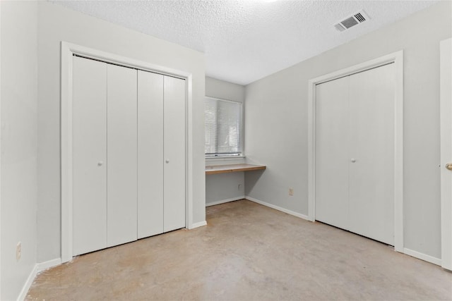 6201 Berkett Cv, Austin, TX 78745 - unfurnished bedroom featuring concrete floors, a textured ceiling, and a closet