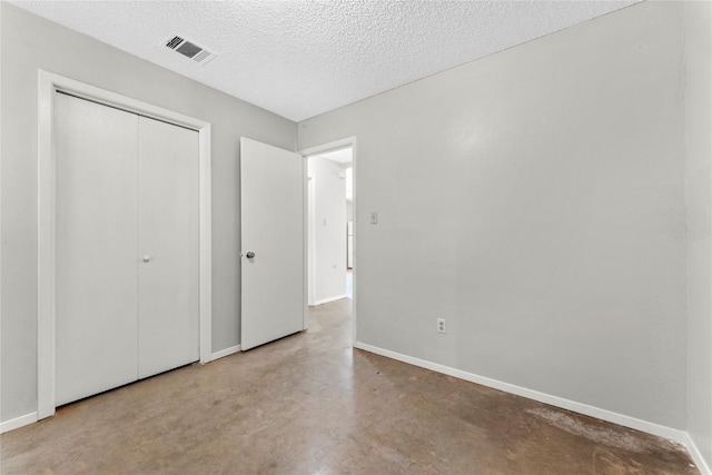 6201 Berkett Cv, Austin, TX 78745 - unfurnished bedroom featuring finished concrete flooring, a closet, and a textured ceiling