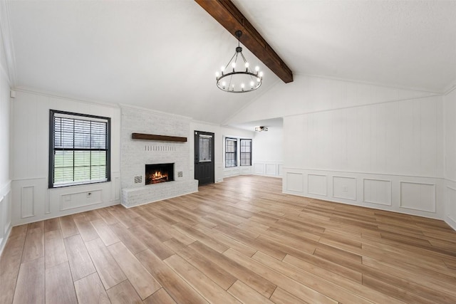 1107 Timmons Dr, Copperas Cove, TX 76522 - unfurnished living room featuring a decorative wall, light wood finished floors, a chandelier, and a brick fireplace