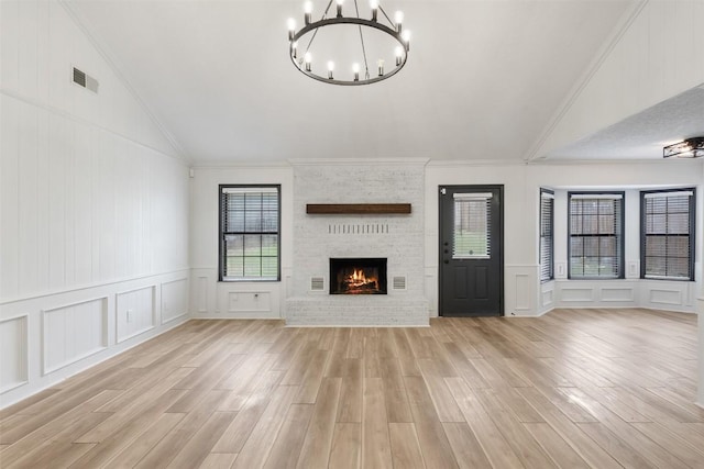 1107 Timmons Dr, Copperas Cove, TX 76522 - unfurnished living room featuring a decorative wall, lofted ceiling, ornamental molding, a chandelier, and light wood-style flooring