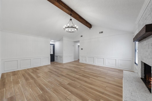 1107 Timmons Dr, Copperas Cove, TX 76522 - unfurnished living room featuring a decorative wall, a brick fireplace, light wood finished floors, a chandelier, and a wainscoted wall