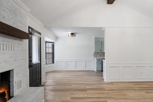 1107 Timmons Dr, Copperas Cove, TX 76522 - unfurnished living room with a decorative wall, lofted ceiling, crown molding, light wood-style flooring, and a fireplace