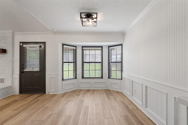 1107 Timmons Dr, Copperas Cove, TX 76522 - unfurnished dining area featuring ornamental molding, a decorative wall, plenty of natural light, and light wood-style floors