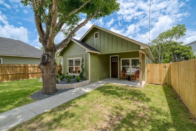 815 Fir Ln, Lockhart, TX 78644 - view of front facade with board and batten siding, a fenced backyard, and a patio