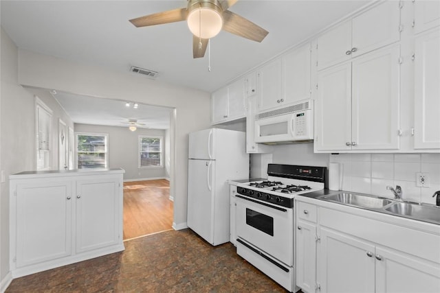 1301 Piedmont Ave, Austin, TX 78757 - kitchen with white appliances, a ceiling fan, white cabinetry, and decorative backsplash