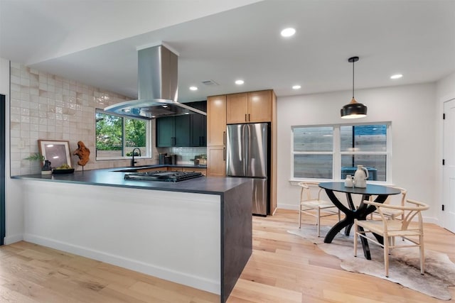 6209 Waycross Dr, Austin, TX 78745 - kitchen with stainless steel appliances, island exhaust hood, a peninsula, dark countertops, and backsplash