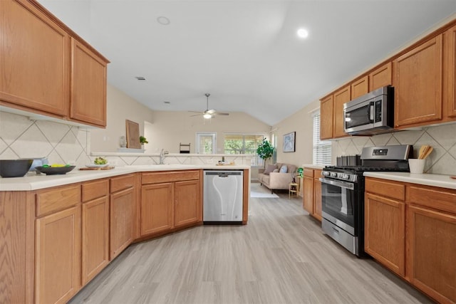 301 River Crossing Trl, Round Rock, TX 78665 - kitchen featuring appliances with stainless steel finishes, a peninsula, backsplash, and lofted ceiling