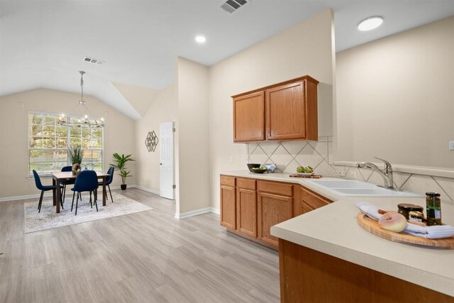 301 River Crossing Trl, Round Rock, TX 78665 - kitchen featuring a chandelier, light wood finished floors, light countertops, backsplash, and hanging light fixtures