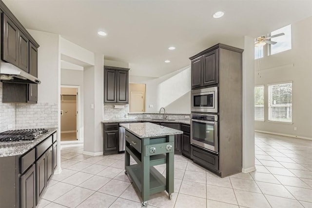 18920 Still Pond Rd, Pflugerville, TX 78660 - kitchen featuring stainless steel appliances, under cabinet range hood, decorative backsplash, light tile patterned flooring, and recessed lighting