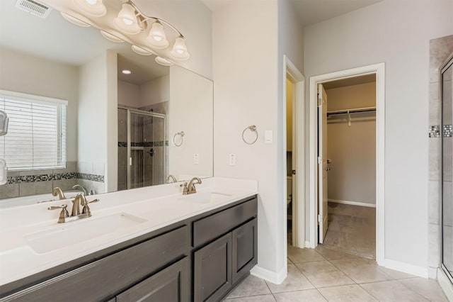 18920 Still Pond Rd, Pflugerville, TX 78660 - full bathroom featuring a stall shower, a walk in closet, double vanity, and tile patterned floors